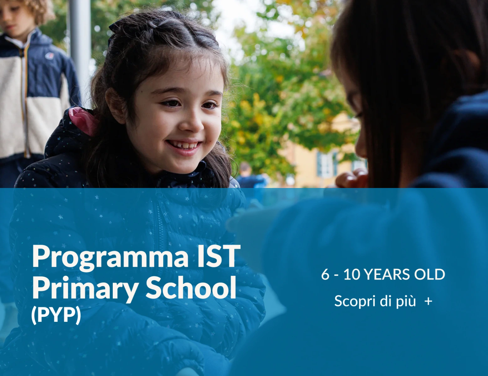 Coppia di bambine sorridenti in conversazione. Nella parte bassa si trova una banda celeste su cui compare la scritta “Programma Primary School (PYP)” , collegata all’omonima sezione